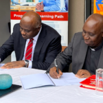 Acorn Holdings Limited CEO, Edward Kirathe (left) andthe Catholic University of Eastern Africa Vice-Chancellor, Rev. Prof. Stephen Mbugua Ngari during the MoU signing ceremony.